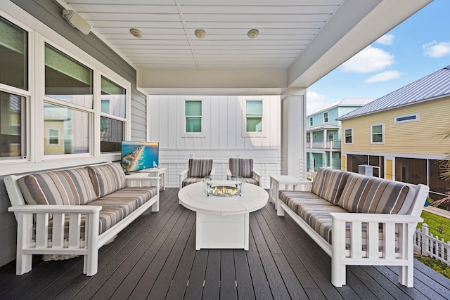 wooden deck featuring an outdoor living space with a fire pit