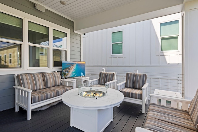 wooden deck with an outdoor living space with a fire pit