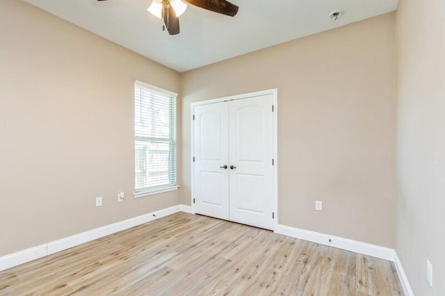 unfurnished bedroom featuring a closet, baseboards, ceiling fan, and light wood-type flooring