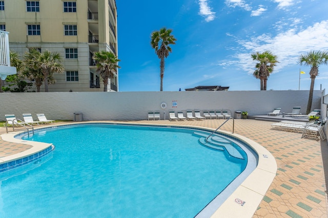 pool with fence and a patio