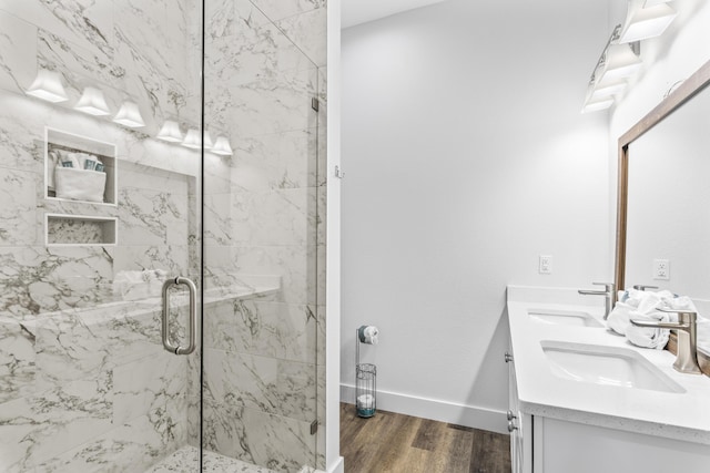 full bath featuring a shower stall, a sink, and wood finished floors