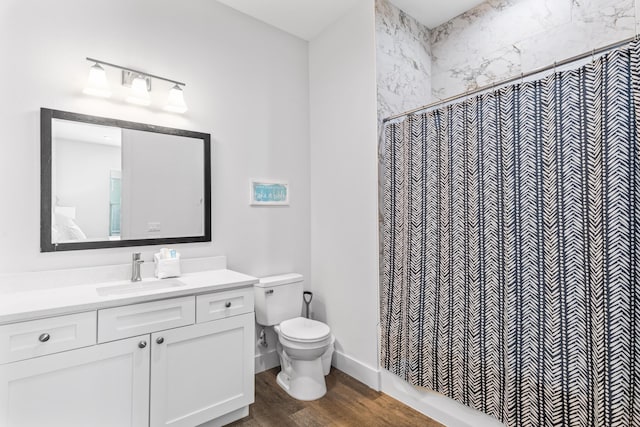 bathroom featuring a shower with curtain, vanity, toilet, wood finished floors, and baseboards