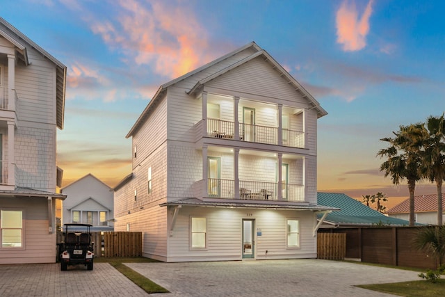 rear view of house with a balcony and fence