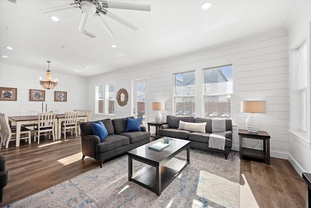 living room with baseboards, recessed lighting, visible vents, ceiling fan with notable chandelier, and wood finished floors