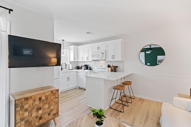 11 Beachside Dr Unit 913, Santa Rosa Beach, FL 32459 - kitchen with white appliances, wainscoting, light wood-type flooring, and a peninsula