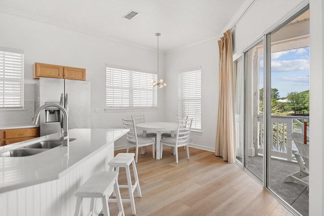 2221 Crystal Cove Ln Unit 2221, Miramar Beach, FL 32550 - kitchen with a breakfast bar, stainless steel fridge, a sink, light wood-style flooring, and visible vents