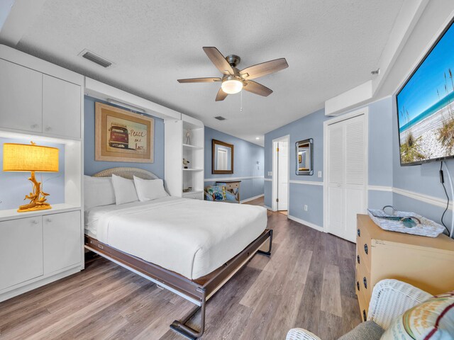 8730 Thomas Dr # 1203C, Panama City Beach, FL 32408 - bedroom featuring baseboards, a textured ceiling, visible vents, a closet, and wood finished floors