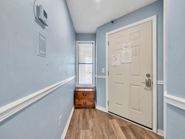 8730 Thomas Dr # 1203C, Panama City Beach, FL 32408 - foyer featuring baseboards, a textured ceiling, and wood finished floors