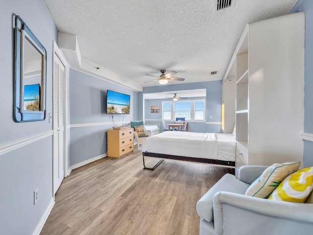 8730 Thomas Dr # 1203C, Panama City Beach, FL 32408 - bedroom featuring baseboards, visible vents, a textured ceiling, and wood finished floors