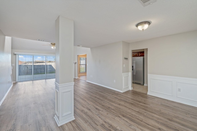spare room with visible vents, light wood-style floors, ceiling fan, and a textured ceiling