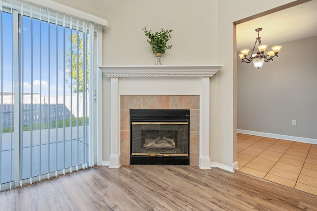 interior details featuring baseboards, a fireplace, wood finished floors, and a notable chandelier