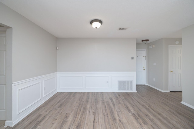 empty room featuring visible vents and light wood-style floors