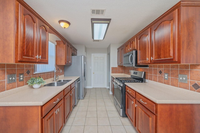 kitchen featuring light countertops, stainless steel appliances, a sink, light tile patterned flooring, and visible vents