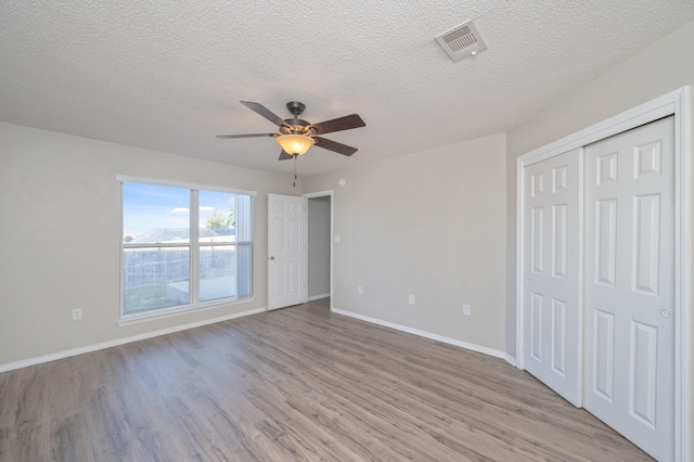 unfurnished bedroom featuring light wood finished floors, baseboards, visible vents, and a ceiling fan