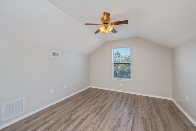 bonus room featuring baseboards, lofted ceiling, visible vents, and wood finished floors