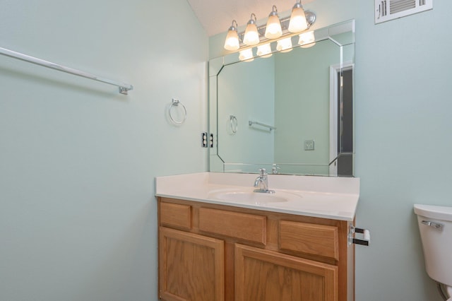 bathroom featuring visible vents, toilet, and vanity