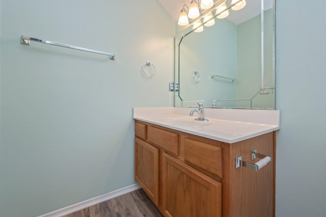 bathroom featuring baseboards, wood finished floors, and vanity