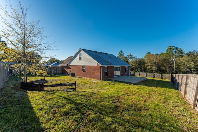 back of property featuring a patio, brick siding, a fenced backyard, and a yard