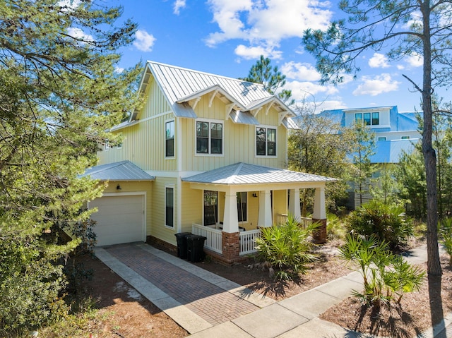 modern inspired farmhouse with a standing seam roof, board and batten siding, metal roof, decorative driveway, and a porch