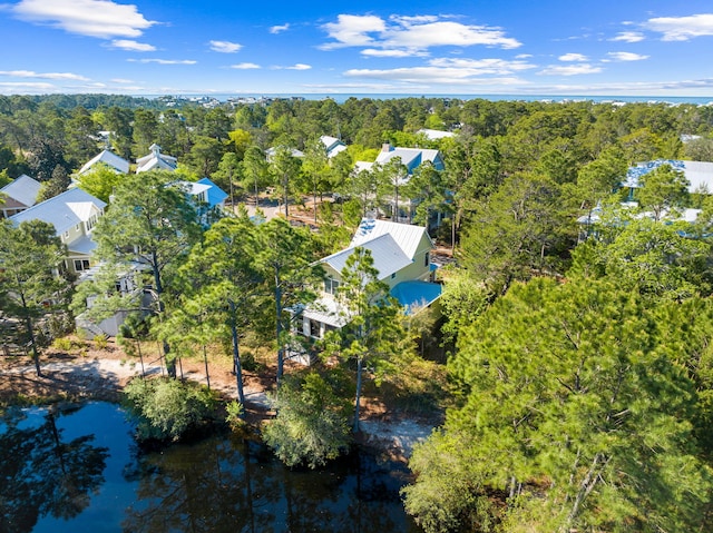 aerial view with a wooded view and a water view