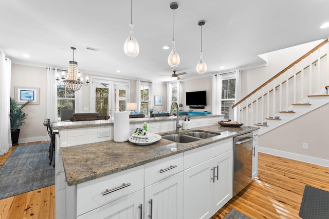 kitchen with visible vents, a sink, stainless steel dishwasher, and crown molding