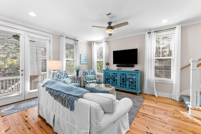 living area featuring hardwood / wood-style floors, a ceiling fan, crown molding, and visible vents