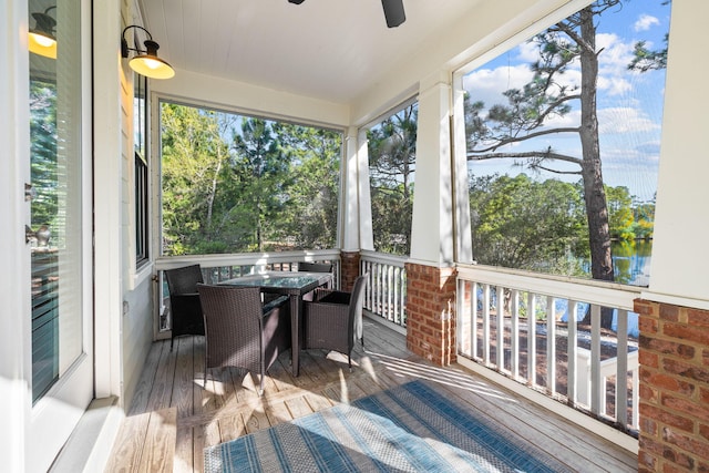 sunroom / solarium featuring outdoor dining space and a ceiling fan