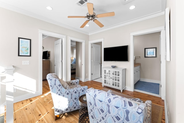 living room featuring crown molding, visible vents, wood finished floors, and a ceiling fan