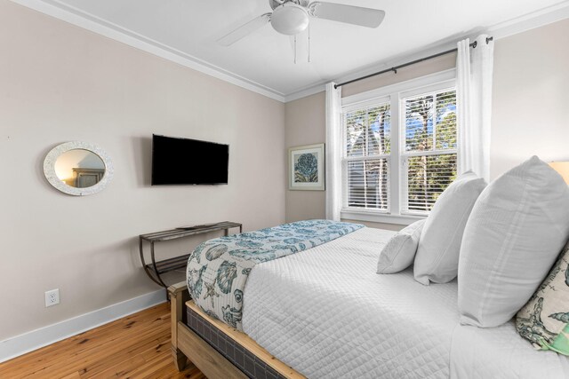 bedroom featuring baseboards, a ceiling fan, wood finished floors, and crown molding
