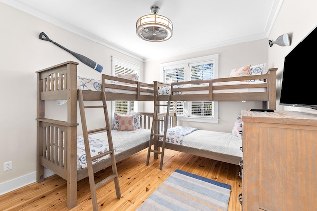 bedroom with baseboards, crown molding, and wood-type flooring