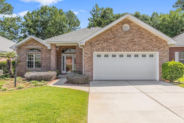 4397 Vardon Way, Niceville, FL 32578 - view of front of house featuring a garage, driveway, a front lawn, and brick siding
