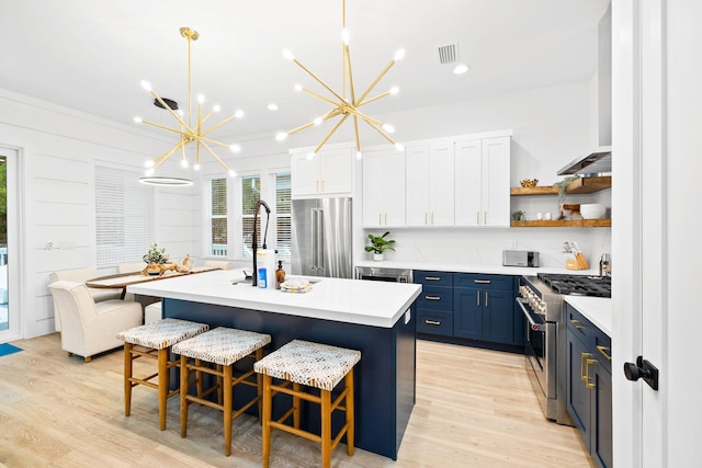 kitchen with light countertops, premium appliances, an inviting chandelier, visible vents, and blue cabinetry