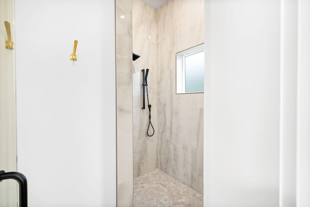 bathroom featuring a marble finish shower