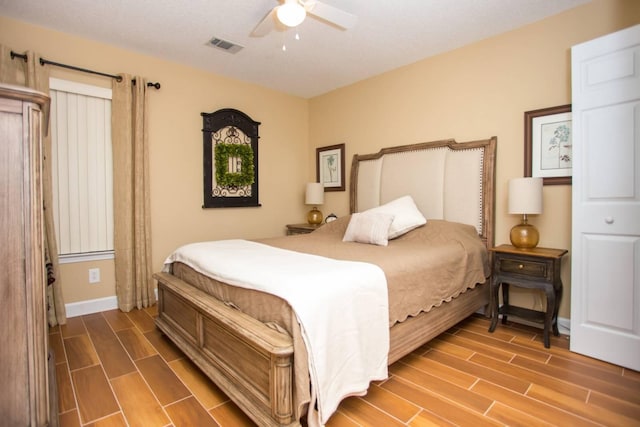 bedroom featuring wood finish floors, baseboards, ceiling fan, and visible vents