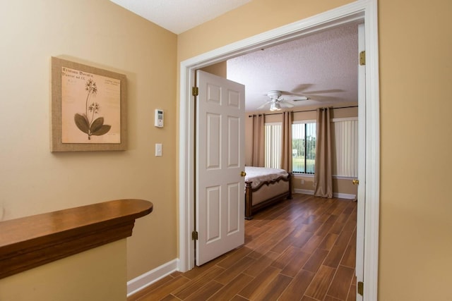 hallway featuring wood finish floors and baseboards