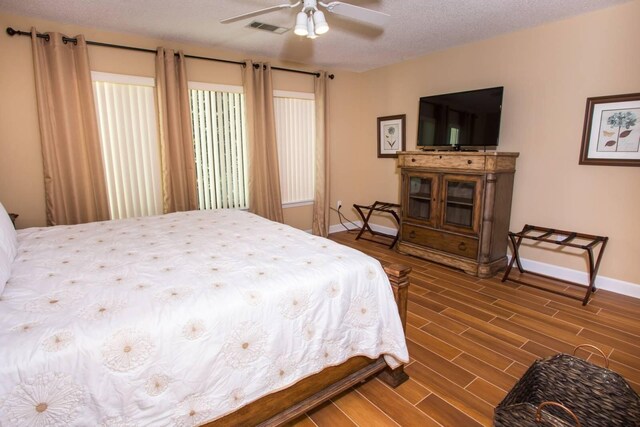 bedroom with wood finish floors, baseboards, and visible vents