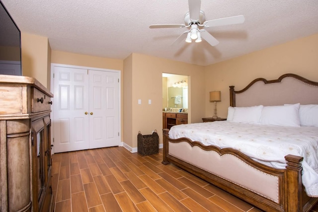 bedroom with baseboards, a textured ceiling, dark wood finished floors, connected bathroom, and a closet