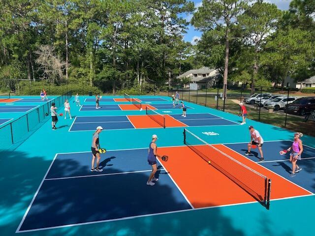 view of tennis court featuring community basketball court and fence