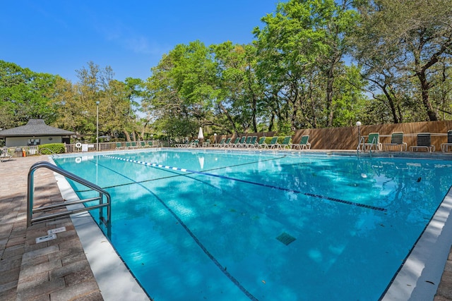 community pool featuring fence and a patio