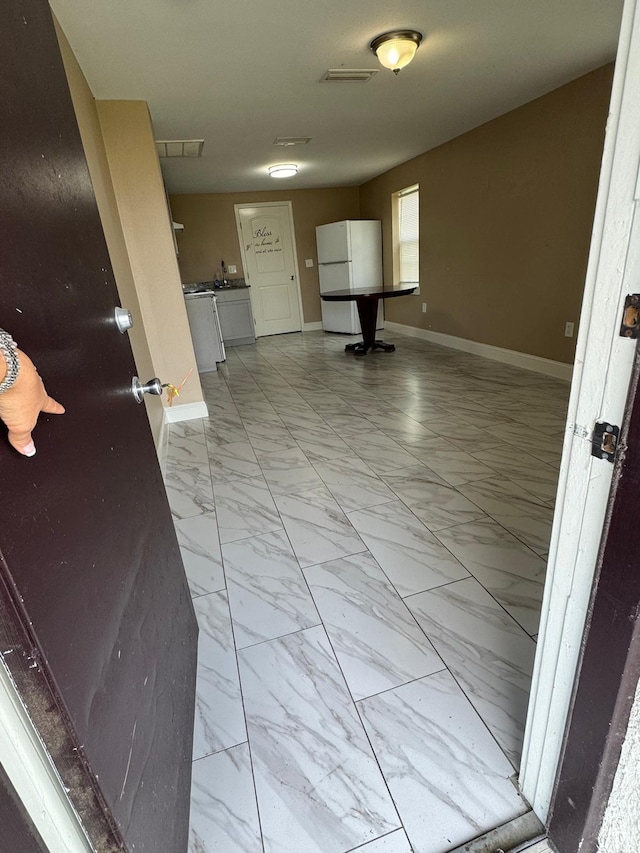 interior space featuring marble finish floor, baseboards, and visible vents