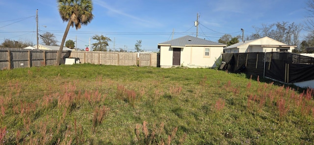 view of yard with a fenced backyard and an outbuilding