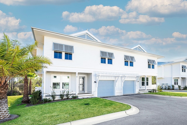 view of front of house with a front lawn, aphalt driveway, and an attached garage