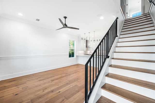 staircase featuring visible vents, crown molding, wood finished floors, recessed lighting, and a ceiling fan