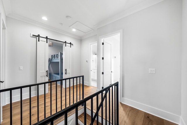 hallway with baseboards, an upstairs landing, wood finished floors, and ornamental molding