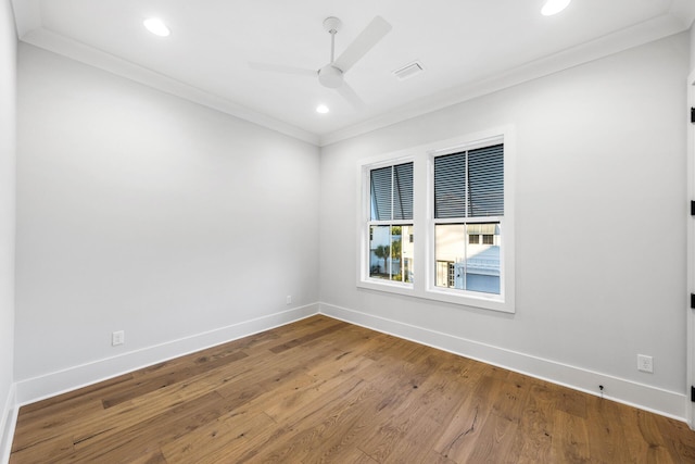 spare room featuring ornamental molding, visible vents, ceiling fan, and wood finished floors