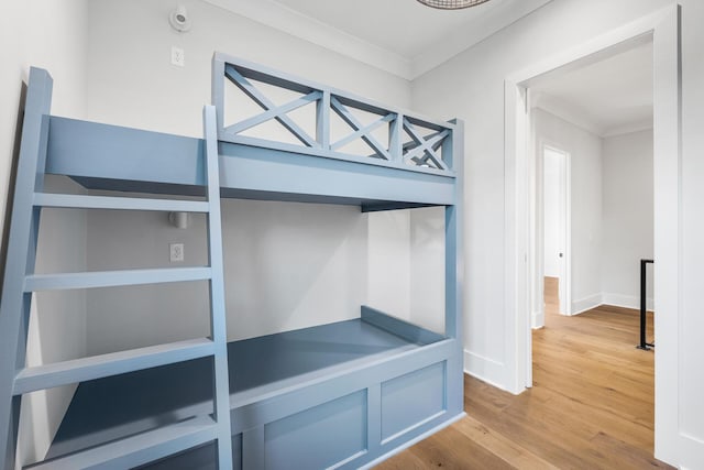 unfurnished bedroom with baseboards, wood finished floors, and crown molding