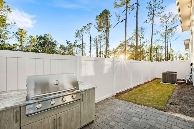 view of patio / terrace with cooling unit, grilling area, and a fenced backyard