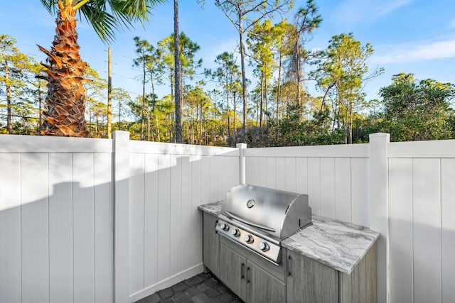 view of patio with area for grilling and fence