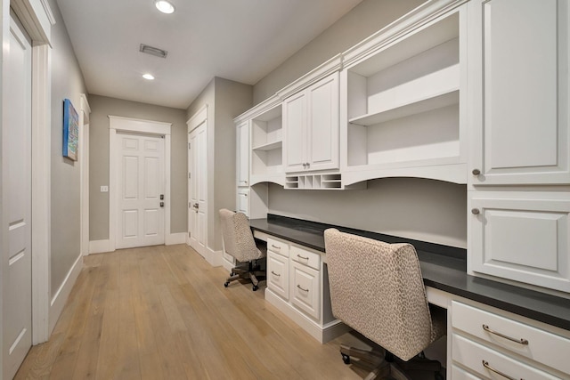 unfurnished office with built in study area, recessed lighting, light wood-type flooring, baseboards, and visible vents