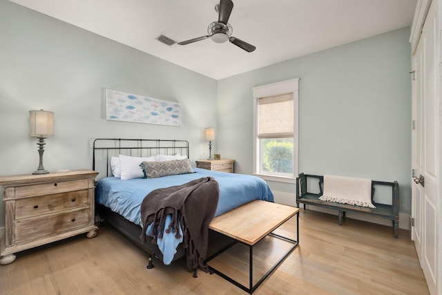 bedroom featuring ceiling fan, visible vents, and light wood finished floors
